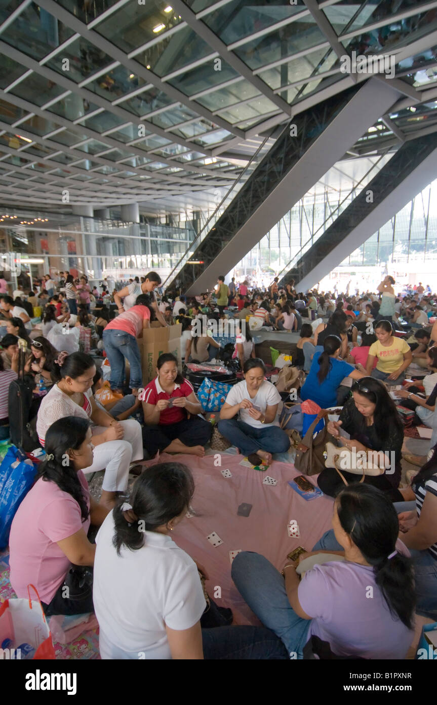 Domestic helpers gather under the shelter of the HSBC building on their