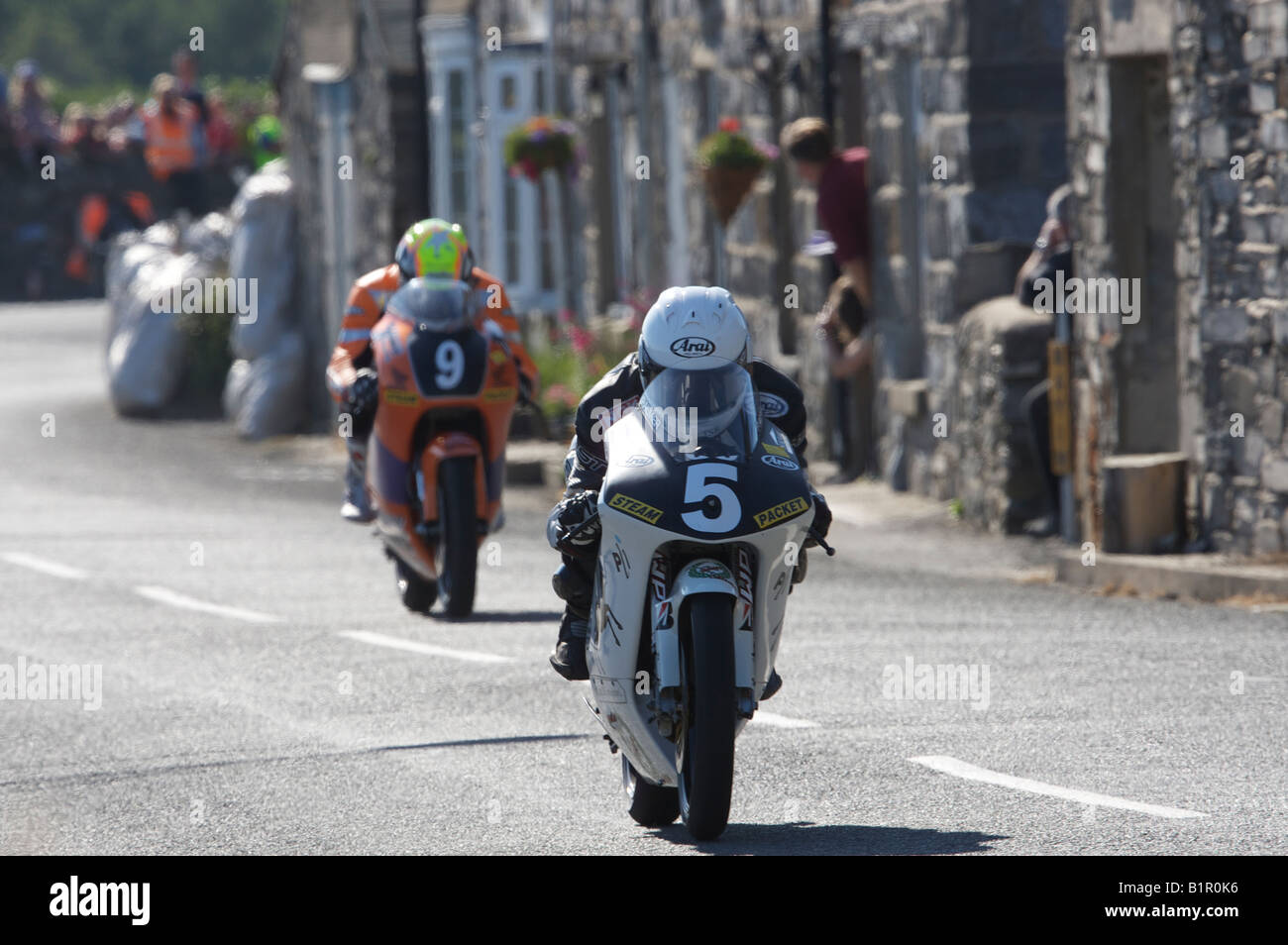 Chris Palmer on his Mannin Honda 250 leads Ian Lougher on his Honda 250 beside the cottages on the exit from Ballabeg hairpin. Stock Photo
