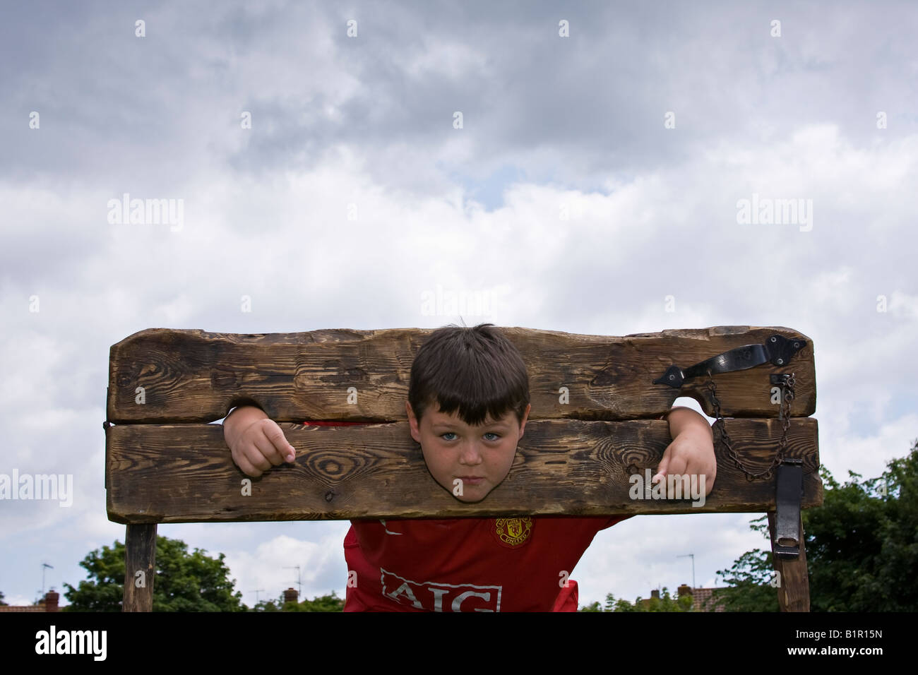 Young boy in the stocks. Sussex, UK Stock Photo