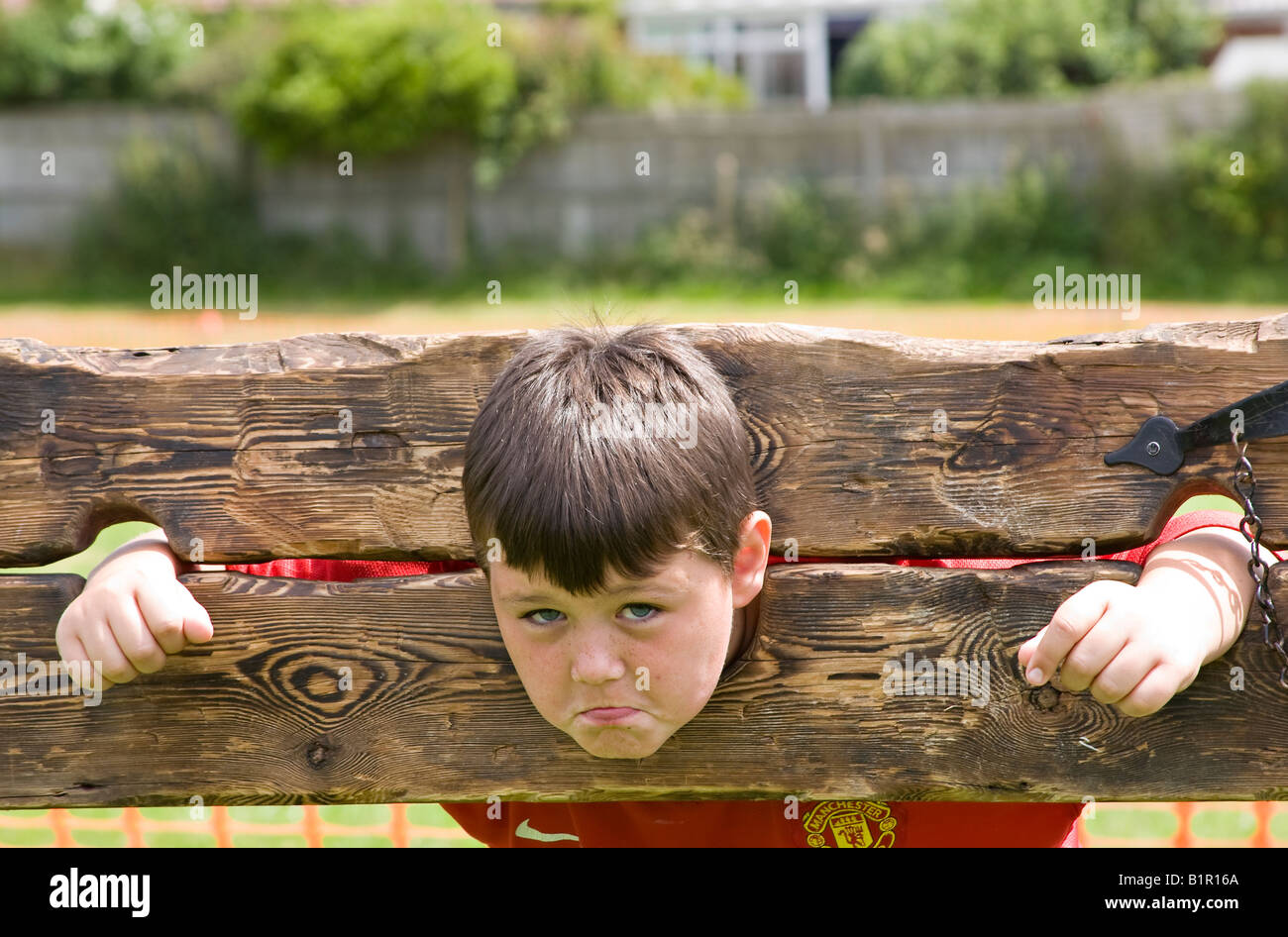 Young boy in wooden stocks. UK Stock Photo