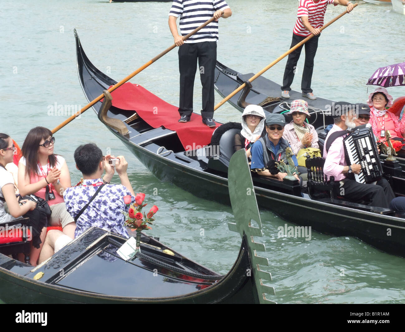 group of oriental tourists on gondola venice italy Stock Photo