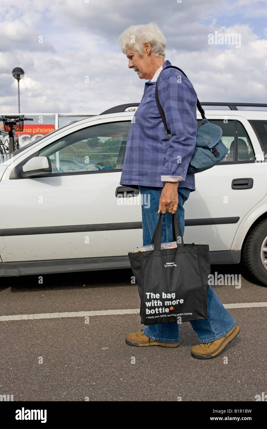 Woman carrying shopping in black Sainsbury recycled bag made from