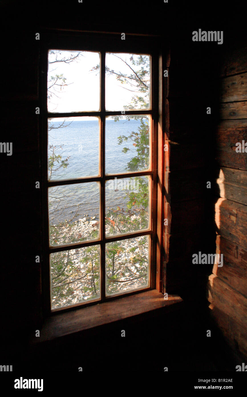 View Of A Rocky Lake Michigan Shore From A Window In A Rustic Log