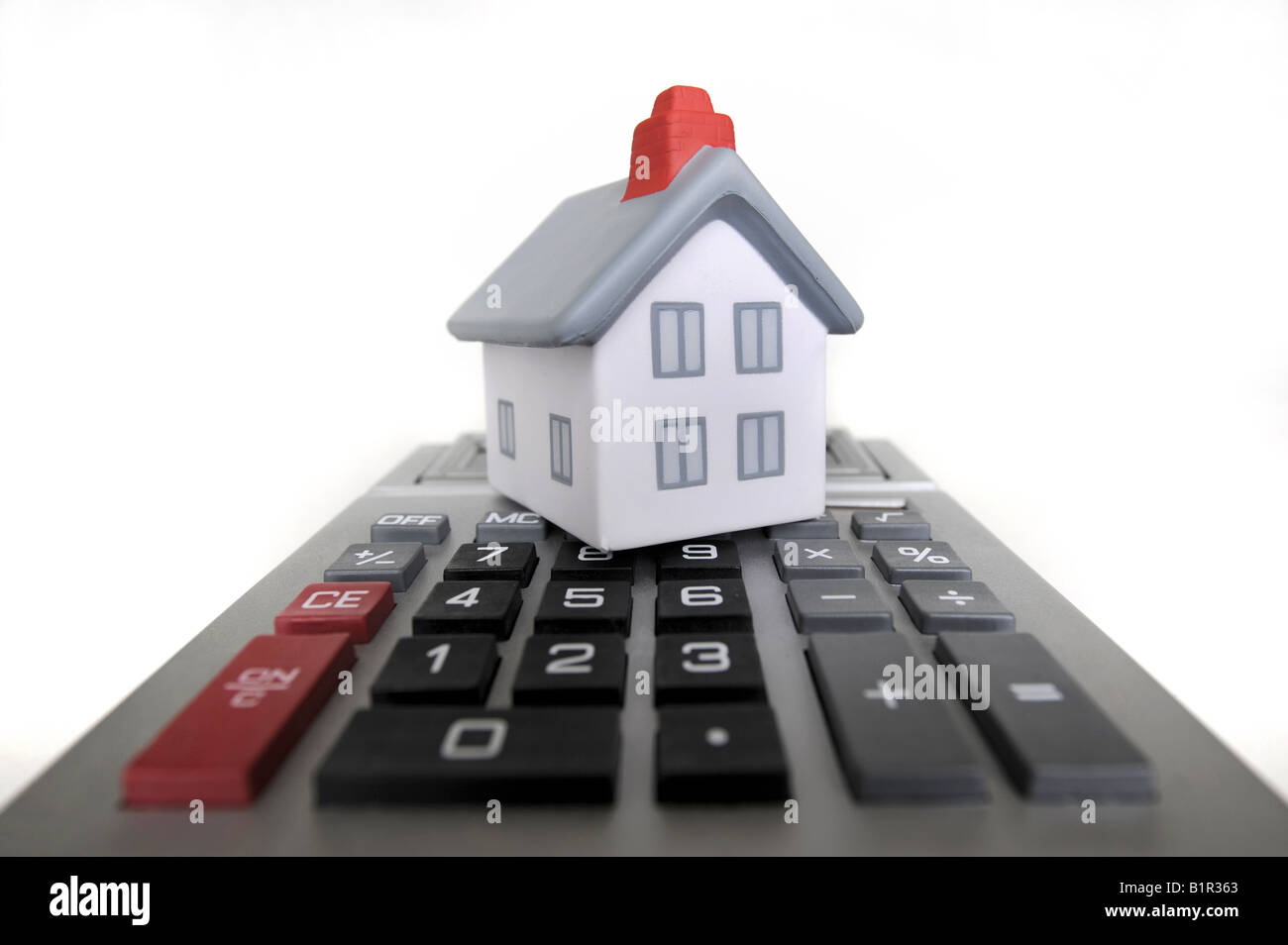 MODEL HOUSE WITH CALCULATOR RE HOUSING COSTS/BILLS/ECONOMY/MARKET Stock Photo