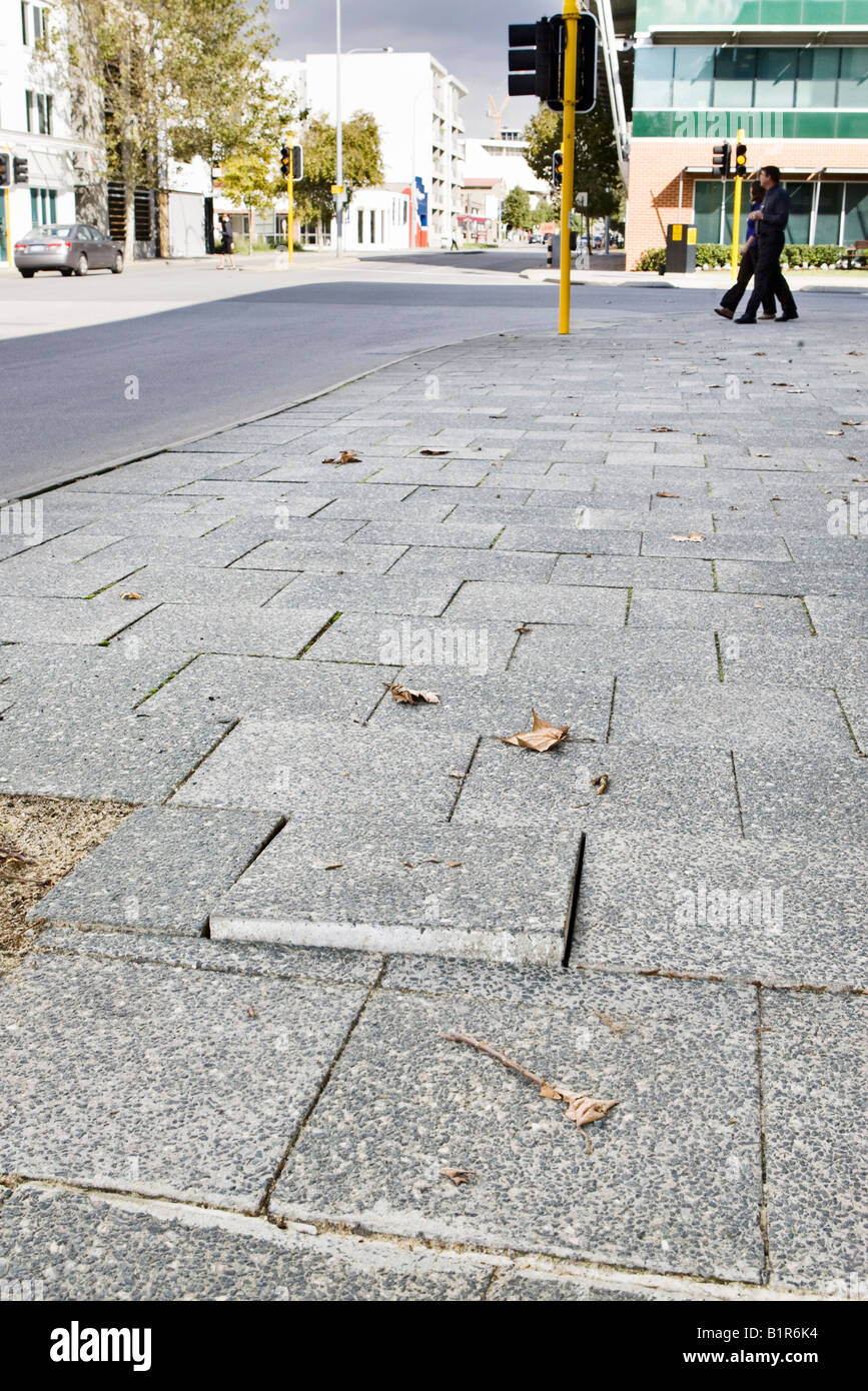 A loose, broken paving slab on a pavement. 'Accident Waiting to Happen' theme Stock Photo