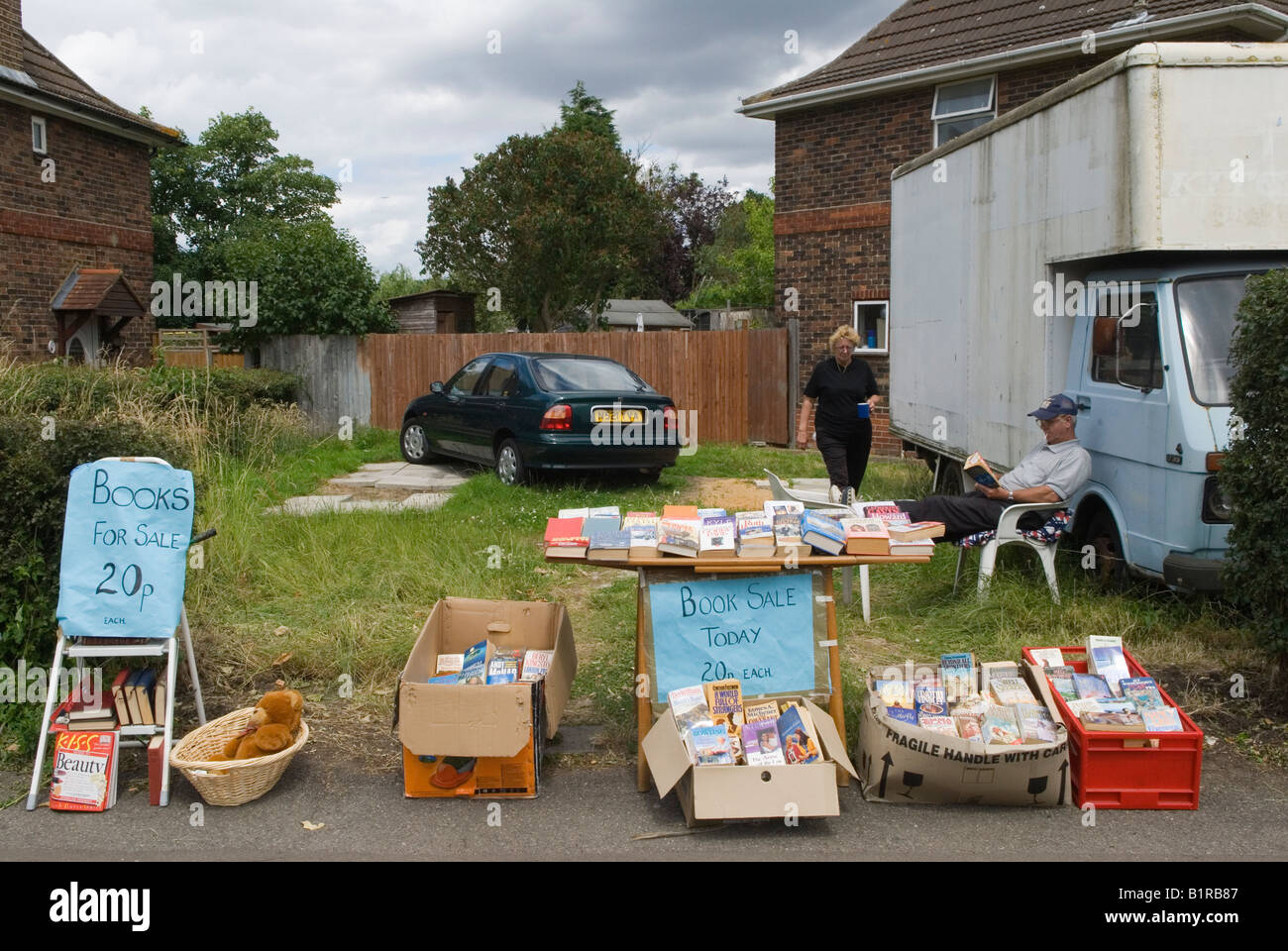 Garage sale retired couple clearing out, selling off some of his their books cheaply suburban London SW20 They are moving home UK  2000s HOMER SYKES Stock Photo