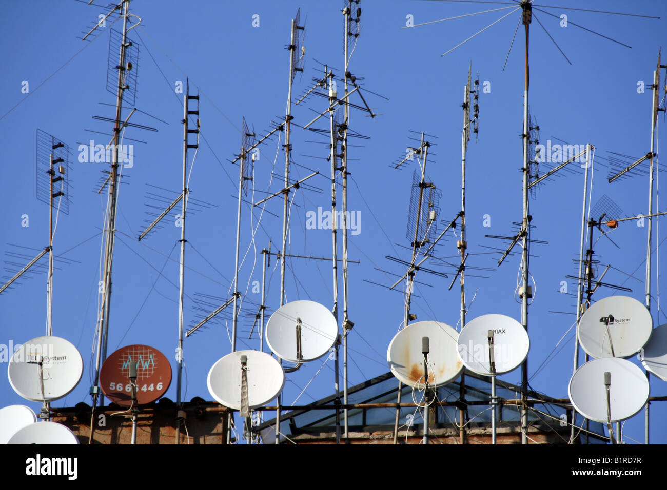 tv aerials and satellite dishes on rooftop Stock Photo Alamy