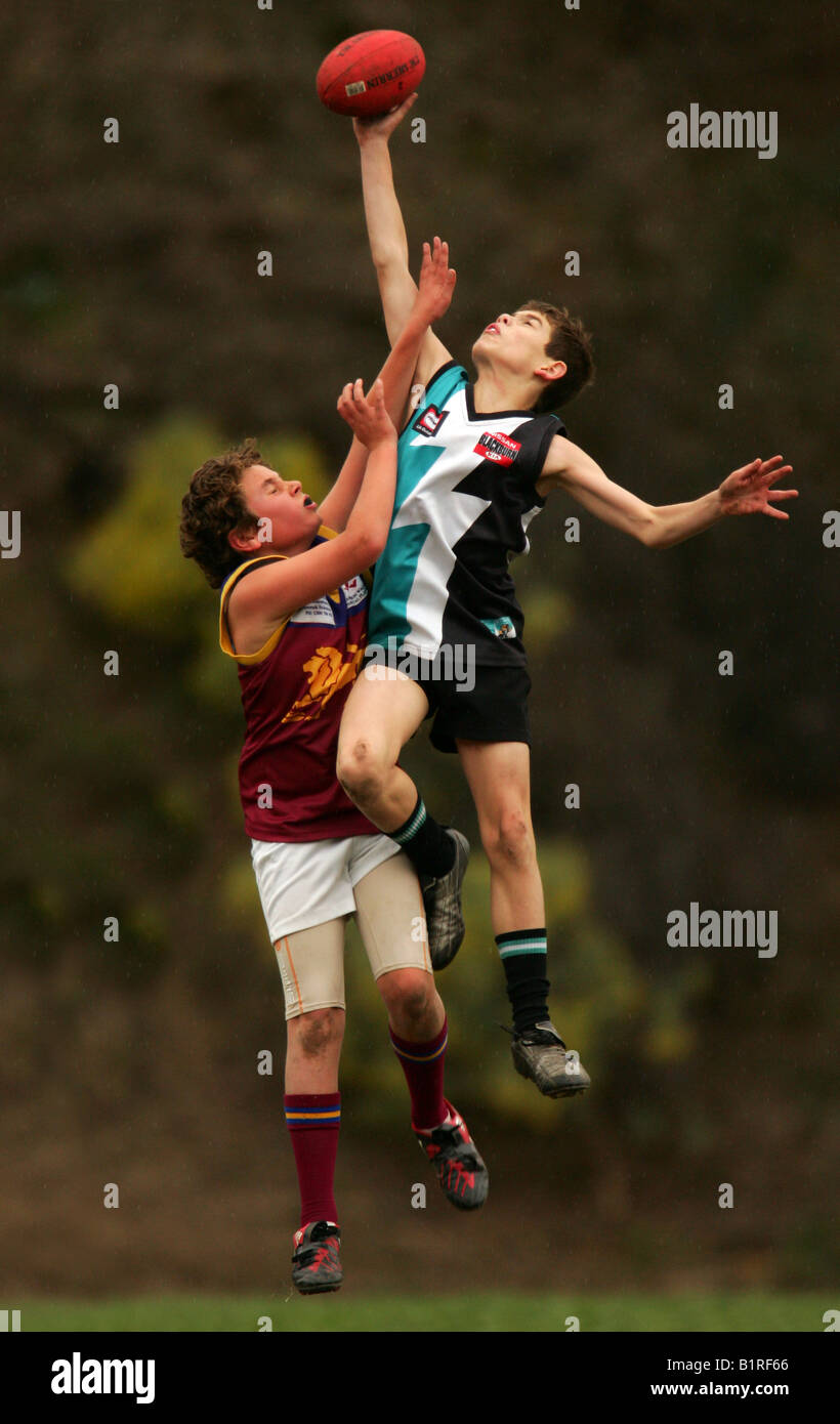 Two players compete for the ball during an Aussie Rules football match in Melbourne, Australia. Stock Photo
