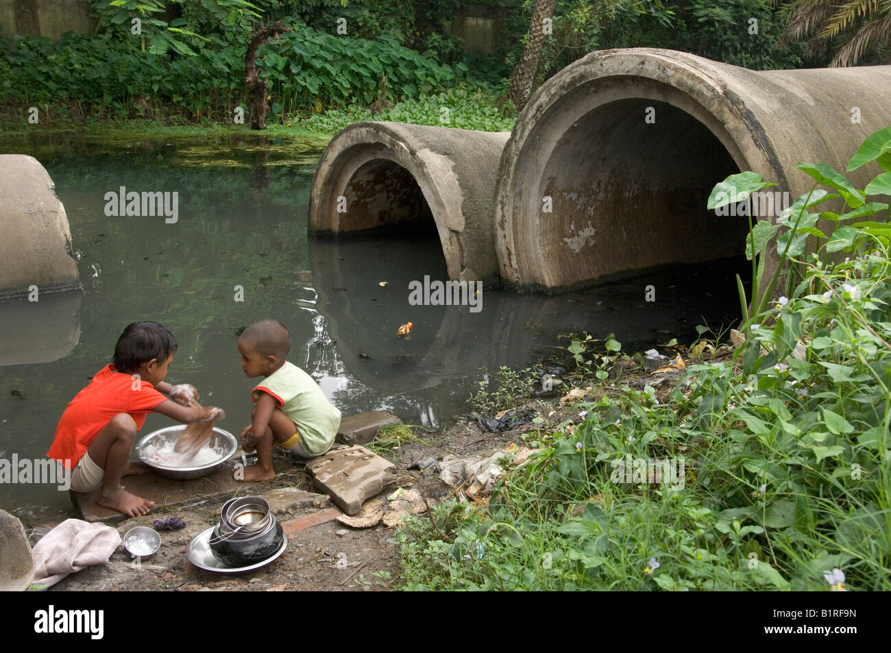 Children washing up in a Calcutta slum, Calcutta, Kolkata, West Bengal, India Stock Photo