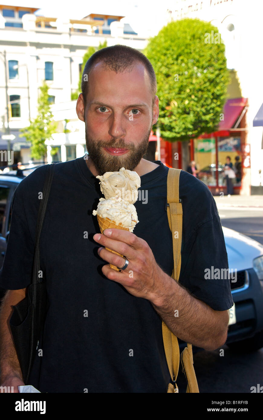 Man enjoying big double scoop ice cream cone in Victoria BC Stock Photo