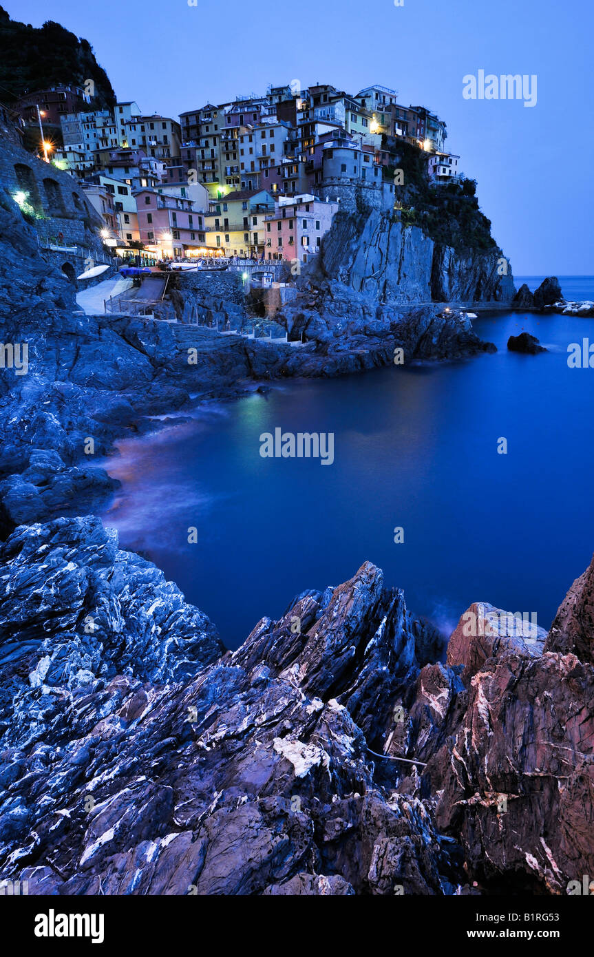 Village of Manarola nestled atop steep coastline at dusk, Liguria, Cinque Terre, Italy, Europe Stock Photo