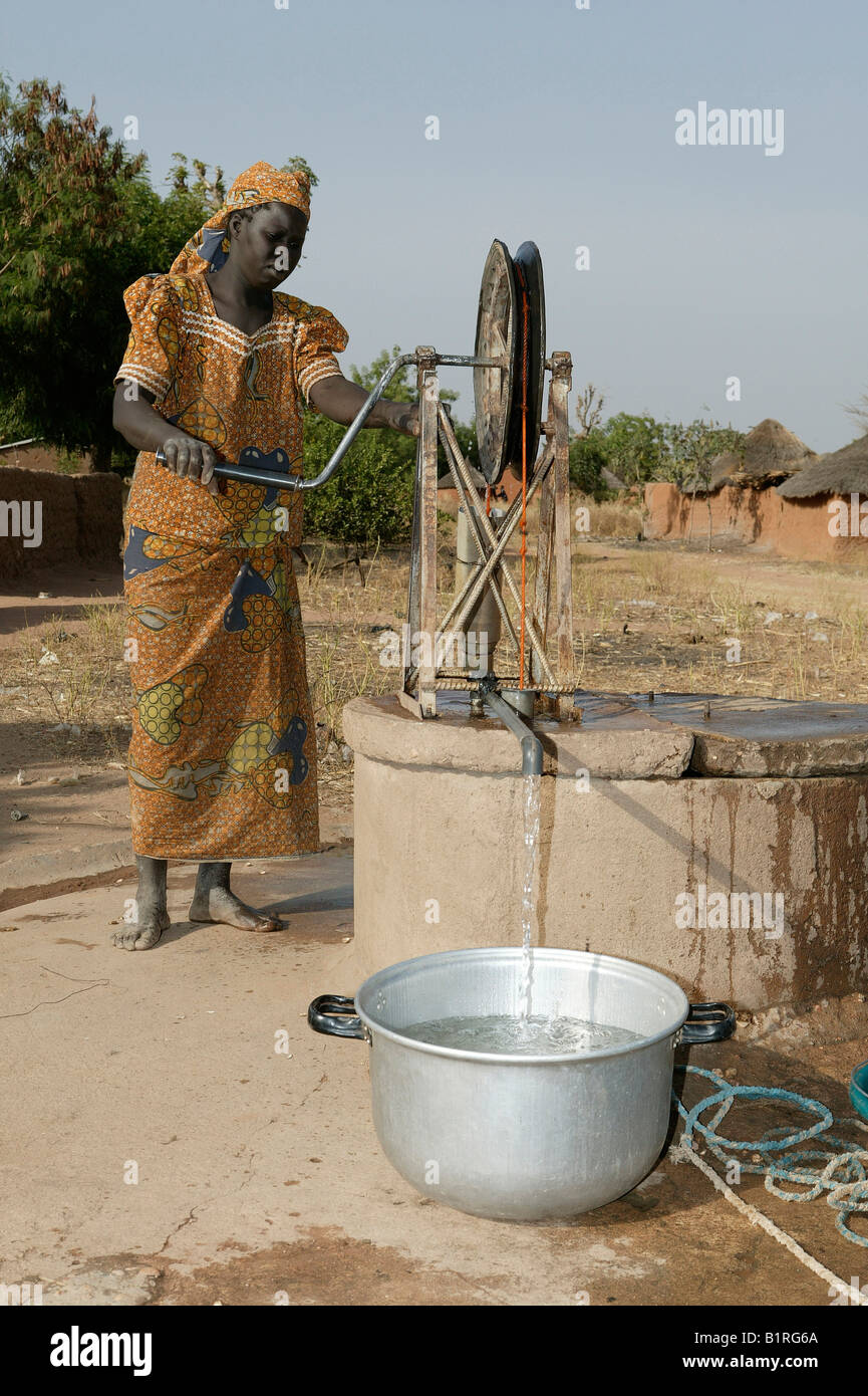 Woman getting water from a wheeled well, Pakete, Cameroon, Africa Stock Photo