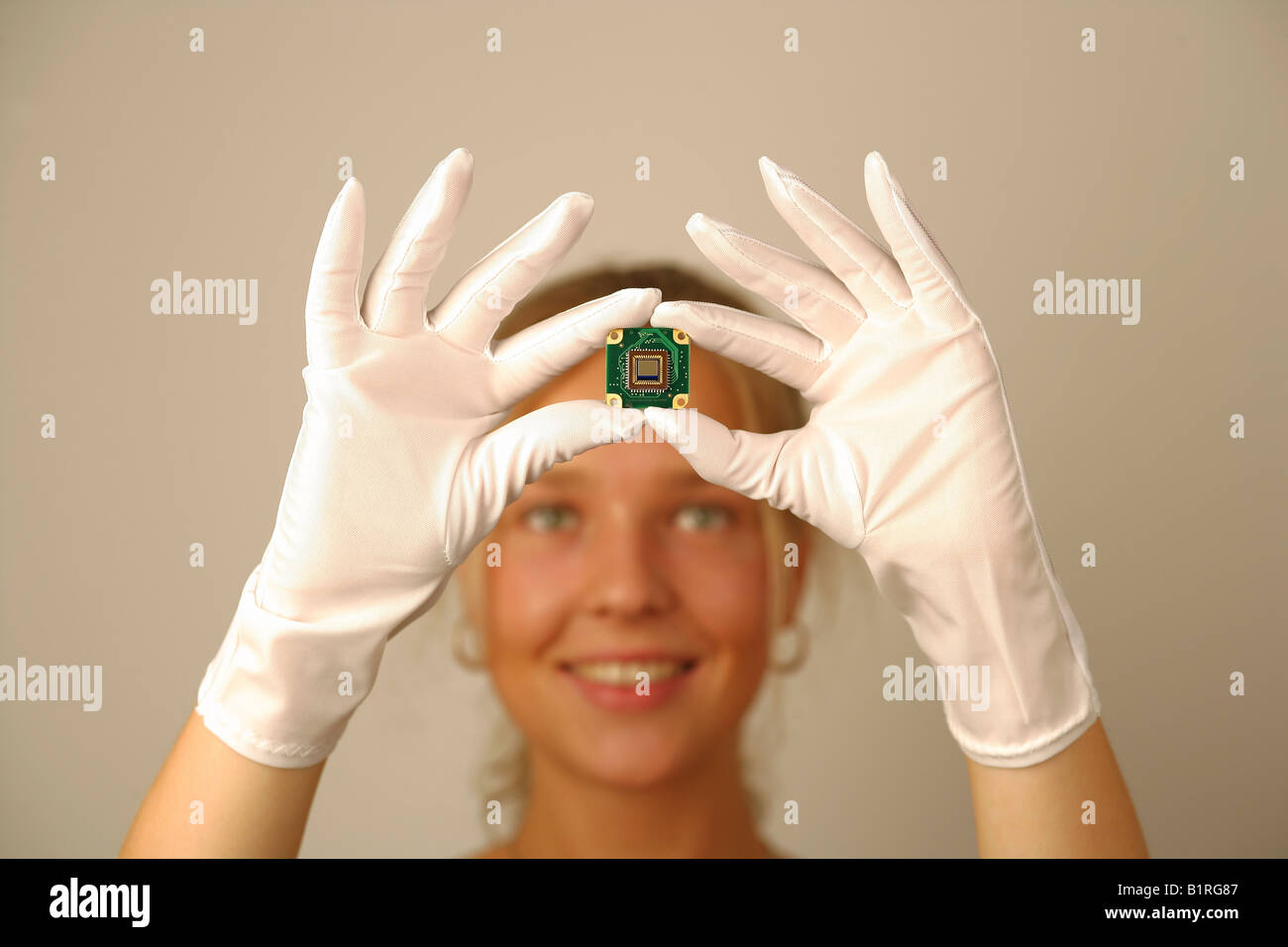 Young woman doing quality control on a microchip, Bavaria, Germany, Europe Stock Photo