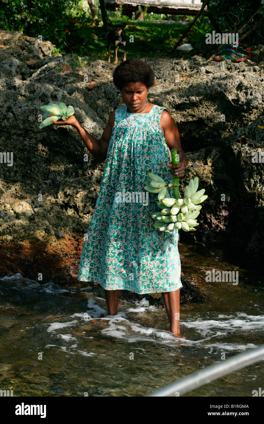 Woman carrying bananas, coastal landscape, Biliau, Papua New Guinea, Melanesia Stock Photo