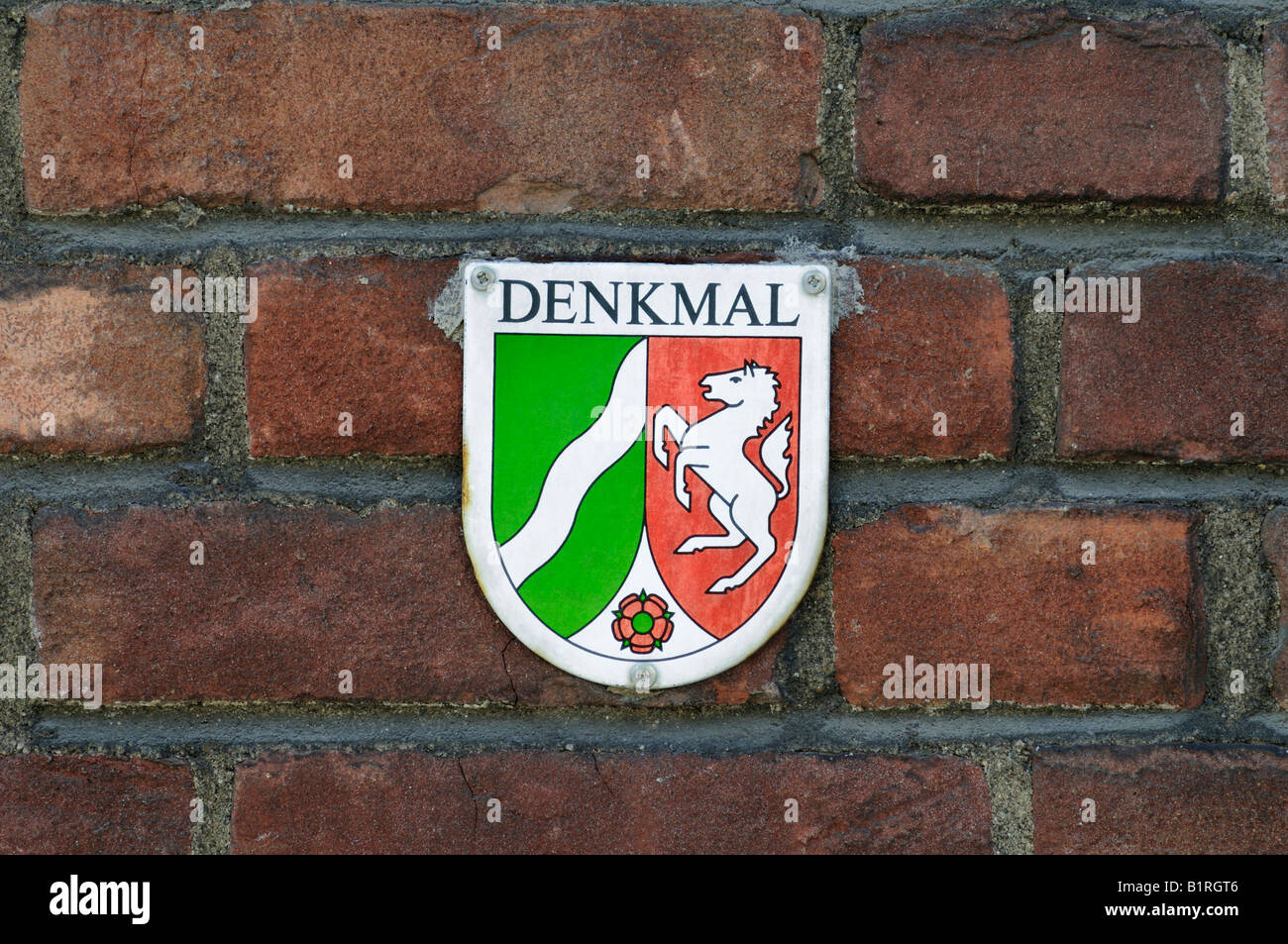 Monument protection sign on an old brick wall, North Rhine-Westphalia coat of arms Stock Photo