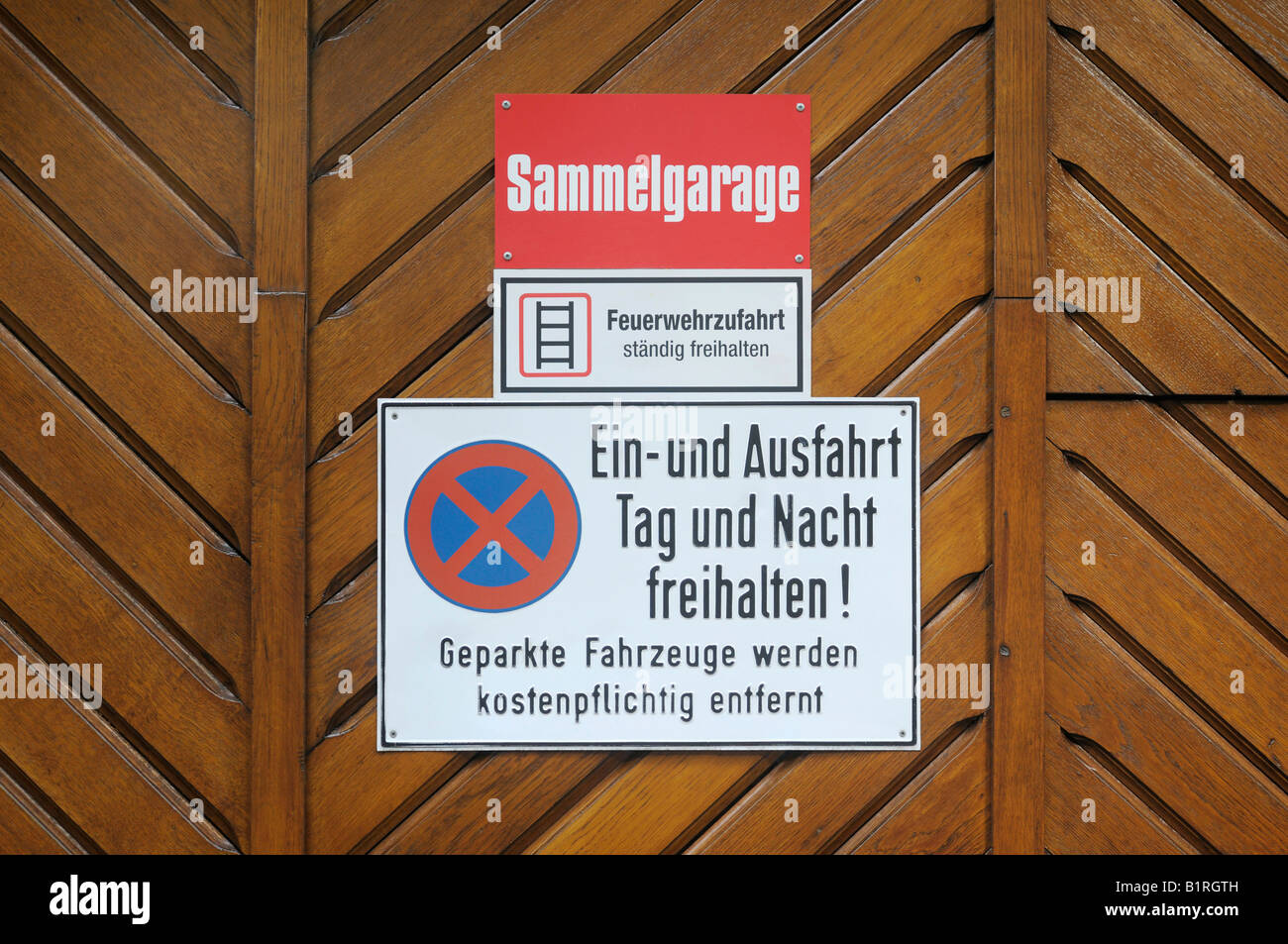 Sign mounted on a wooden garage door, keep fire route clear, no entry