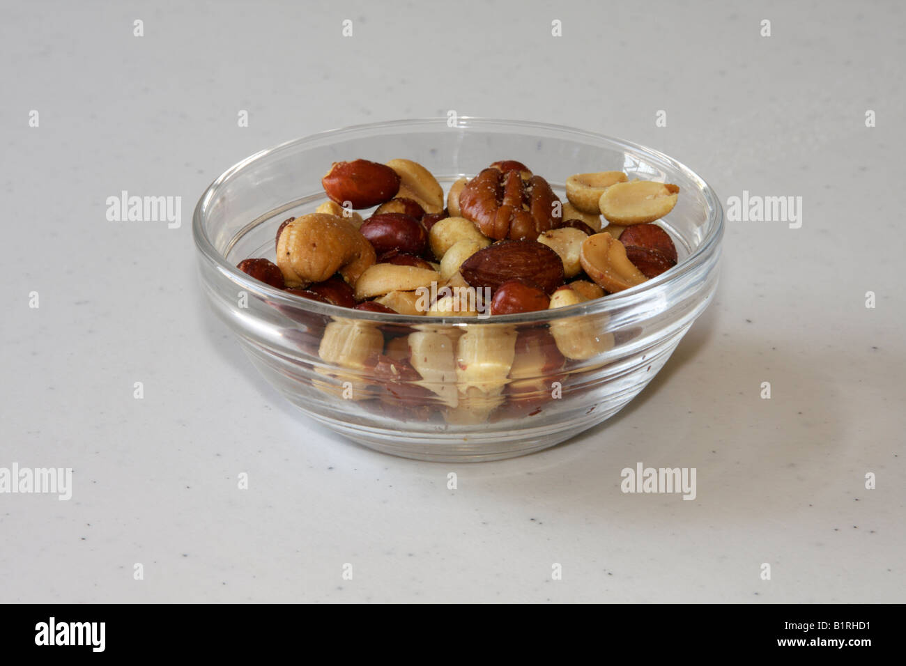 Small glass bowl of salted mixed nuts Stock Photo