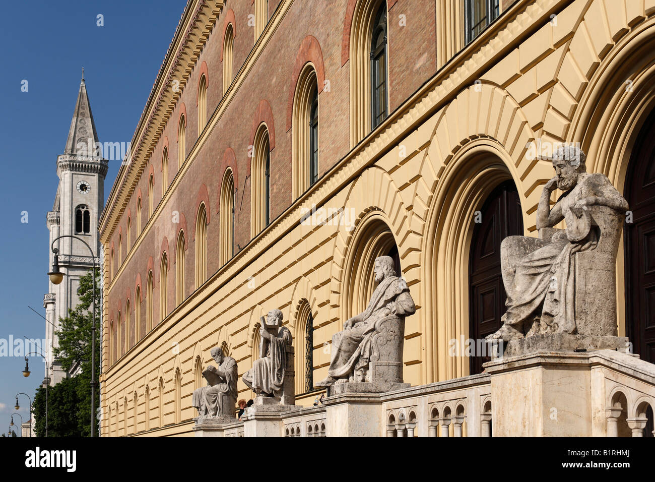 Group of Greek figures in front of the Bavarian State Library in Ludwigstrasse Street, St. Ludwig University Church can be seen Stock Photo