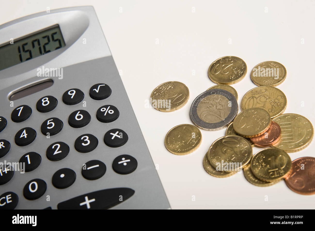 Euro coins next to a calculator Stock Photo - Alamy