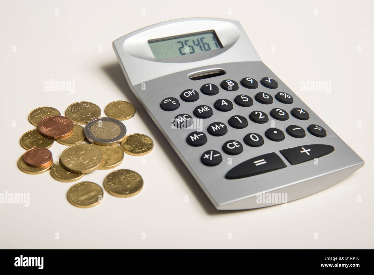 Euro coins lying next to a calculator Stock Photo
