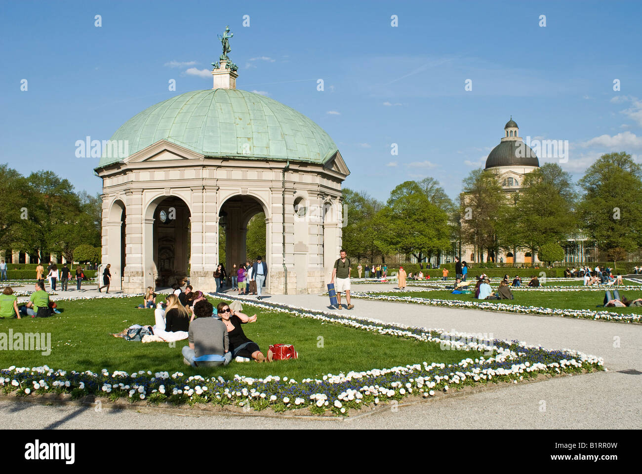 People enjoying the warm spring day in front of the pavilion for the goddess Diana in the Hofgarten, Munich, Bavaria, Germany,  Stock Photo