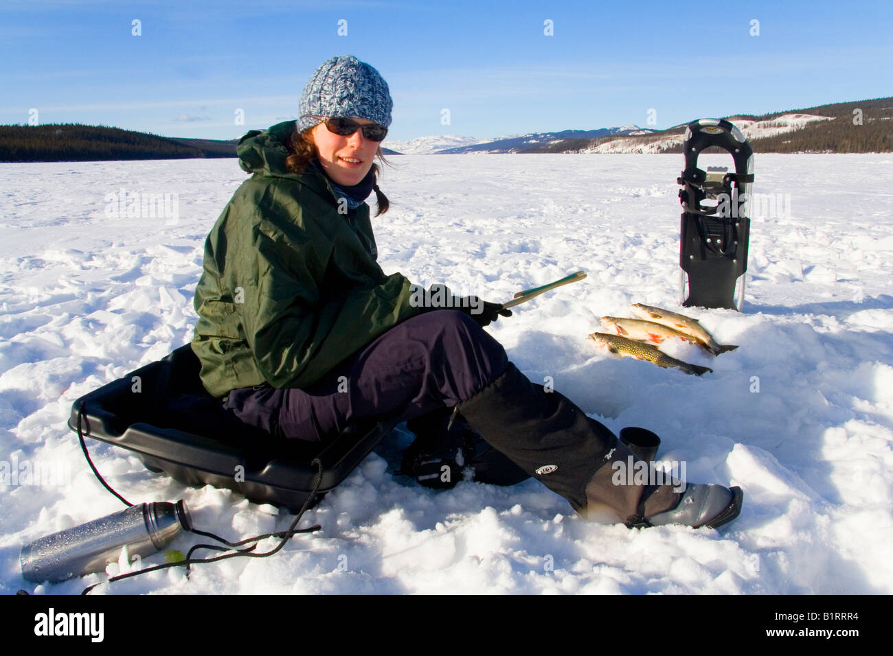 Young woman icefishing, Fox Lake, Yukon Territory, Canada, North Stock