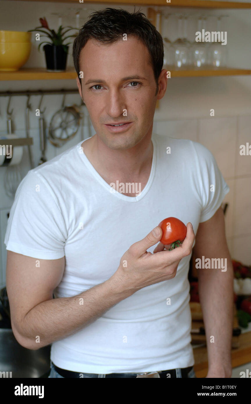 31 year old Man Eating A Tomato In The Kitchen Stock Photo Alamy 31 year old Man Eating A Tomato In The Kitchen Stock Photo Alamy