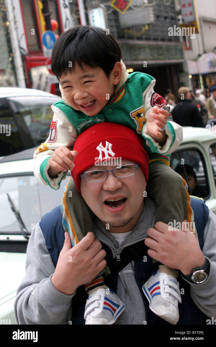 Japanese Child Smiling on his fathers shoulders in China Town in 