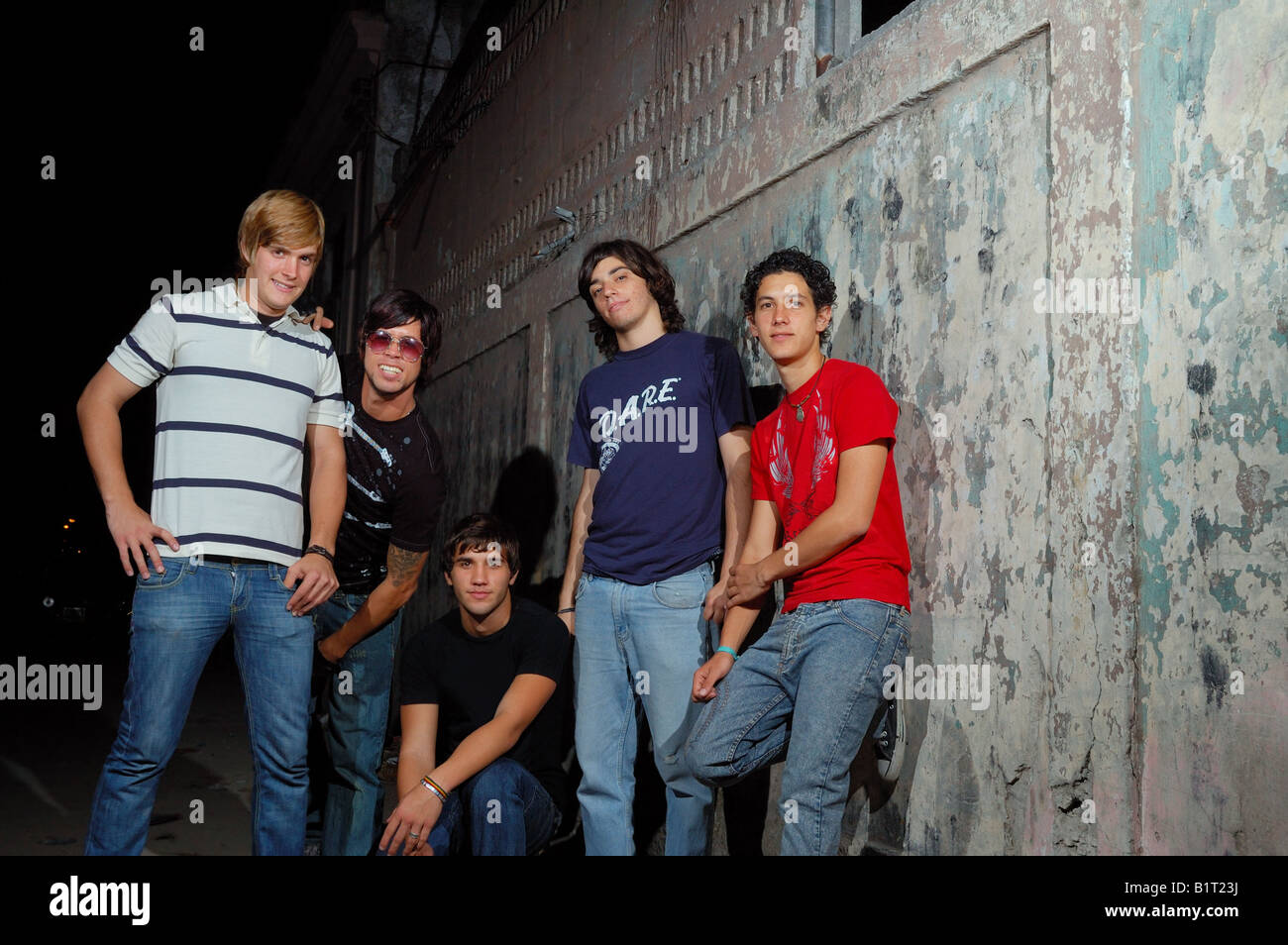Casual group of teenagers standing against grunge wall Stock Photo