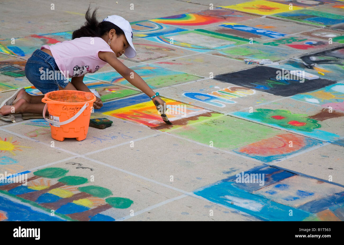 Detroit Michigan A girl paints a square of sidewalk at the Detroit Festival of the Arts Stock Photo