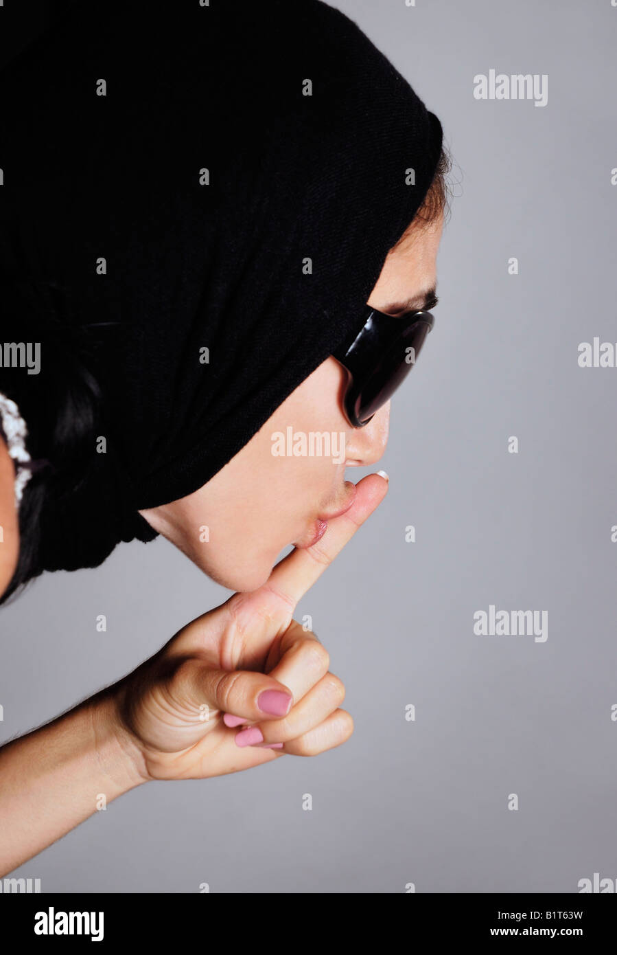 Portrait of young woman profile with finger on lips Stock Photo - Alamy