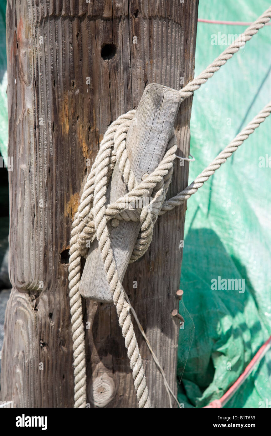 a Cleat with rope securing a tarpaulin Stock Photo - Alamy