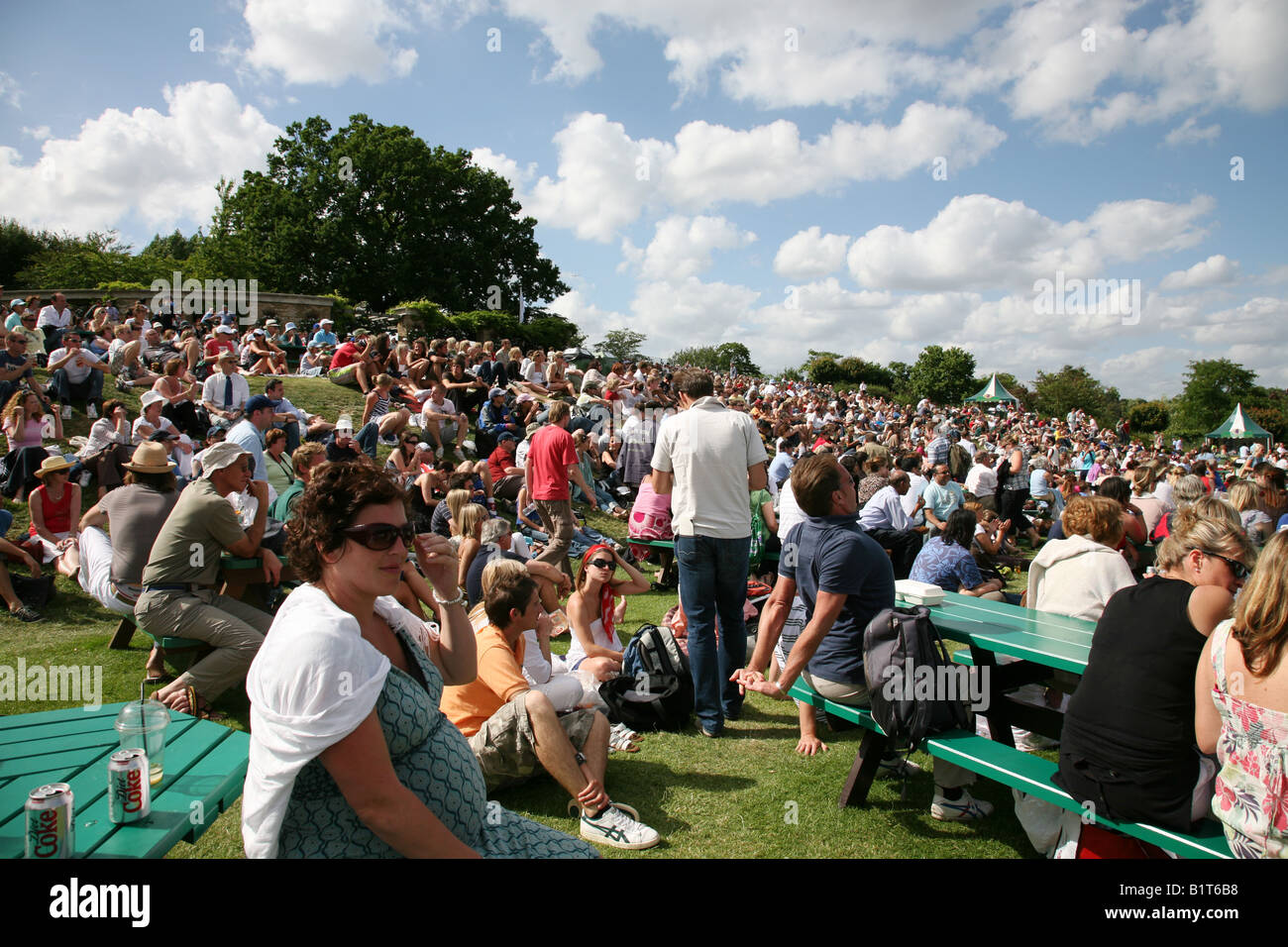 Crowds of spectators sitting on Henman Hill at Wimbledon Tennis Championships having lunch Stock Photo