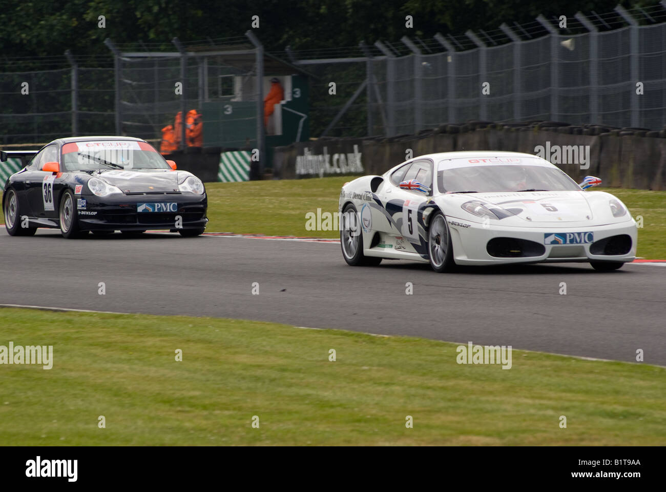 Ferrari 430 and Porsche 996 GT3 Sports Race Cars Exiting Old Hall Corner Oulton Park Motor Racing Circuit Cheshire England Stock Photo