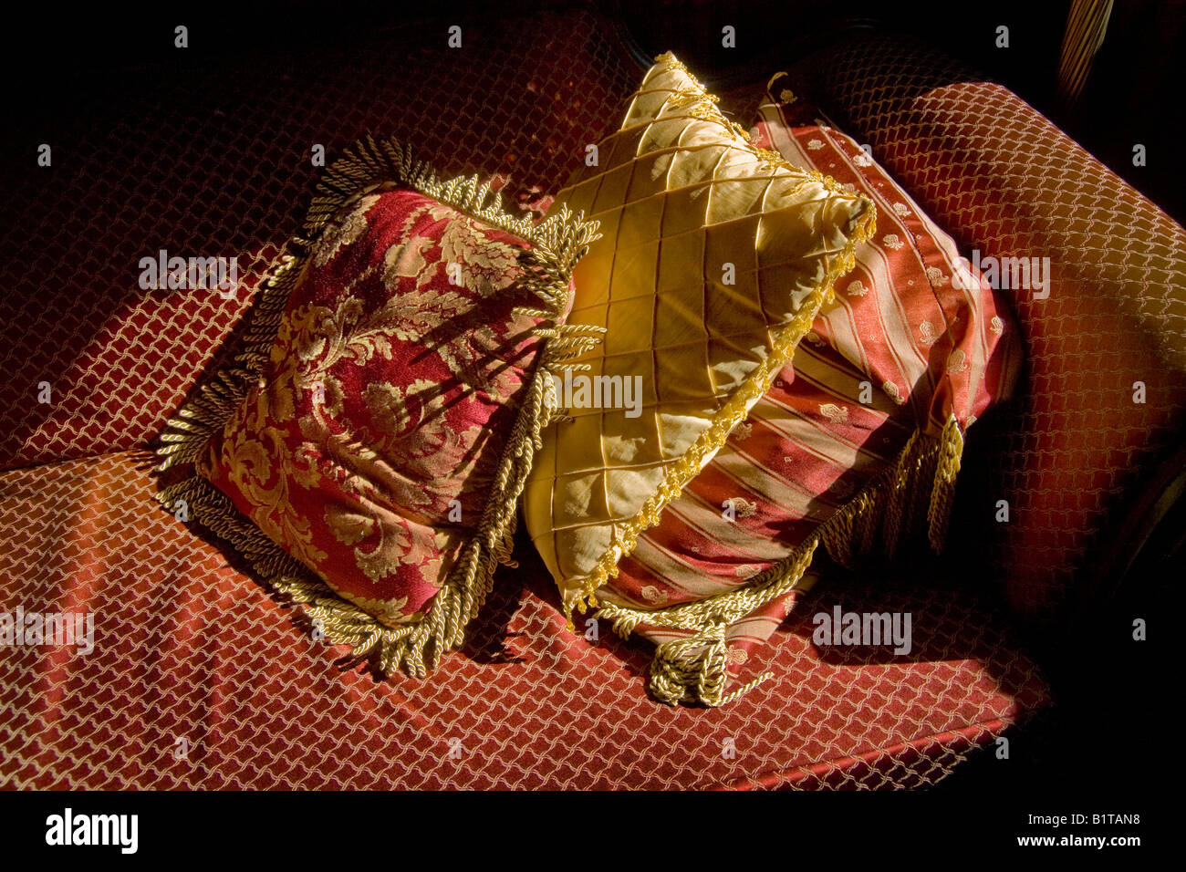 Satin cushions on couch in afternoon sunlight Stock Photo