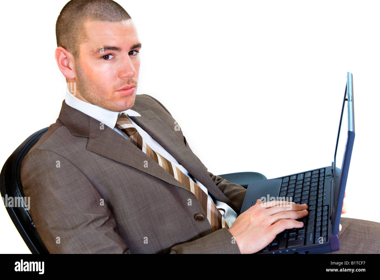 Young businessman sitting on an office chair using a laptop Stock Photo ...