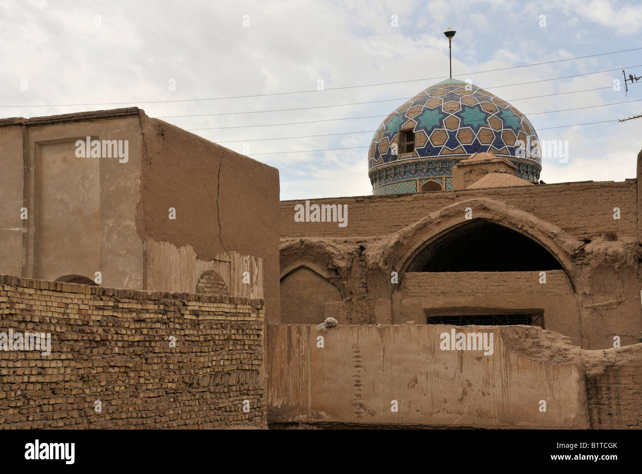 Mosque prominent above the high walls and roof tops in Yazd old sector. Stock Photo