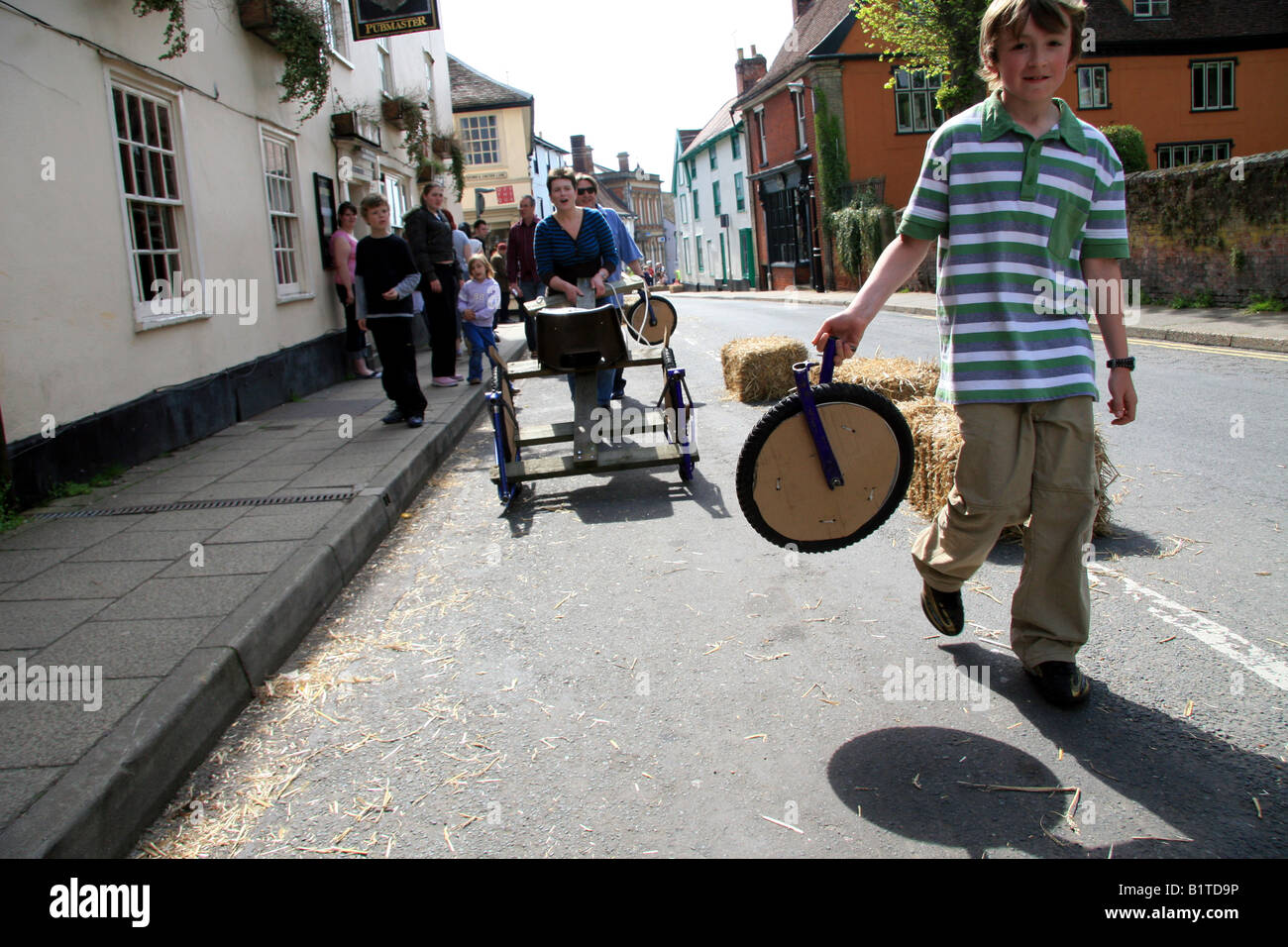 Boy with the broken off wheel of his garvity racing soapbox Stock Photo