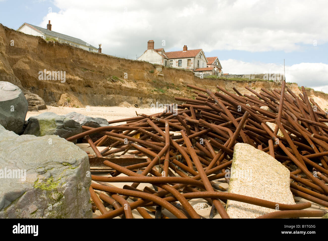 Houses on cliff edge and remains old sea defences after severe coastal ...
