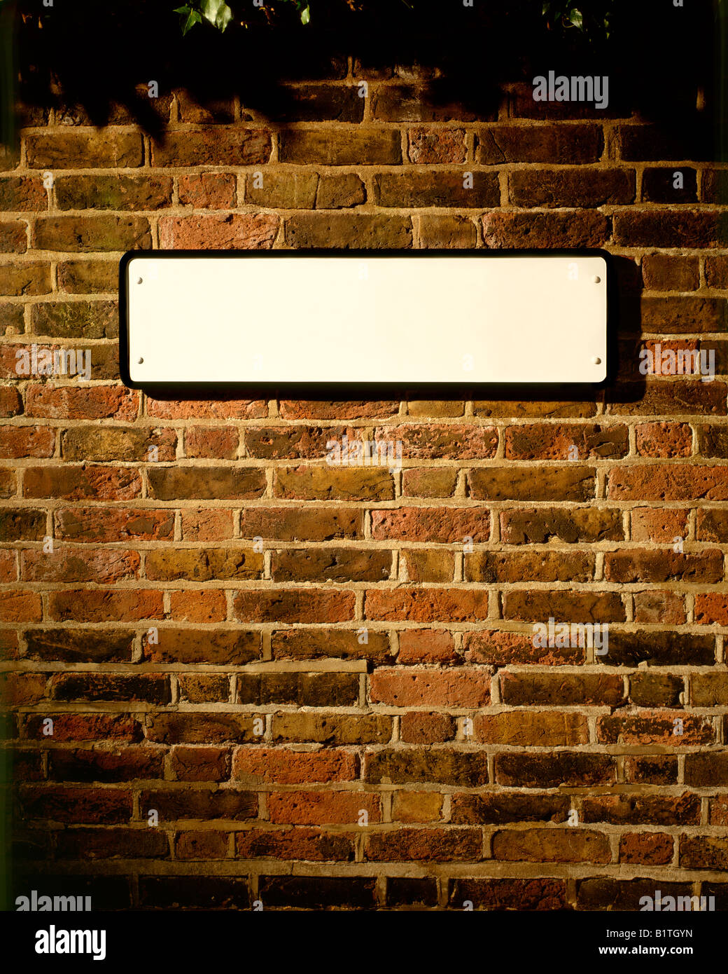 BLANK STREET SIGN ON OLD BRICK WALL Stock Photo