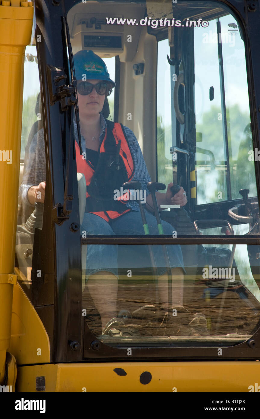 Woman at the controls of a Caterpillar 315CL track excavator, Dig This