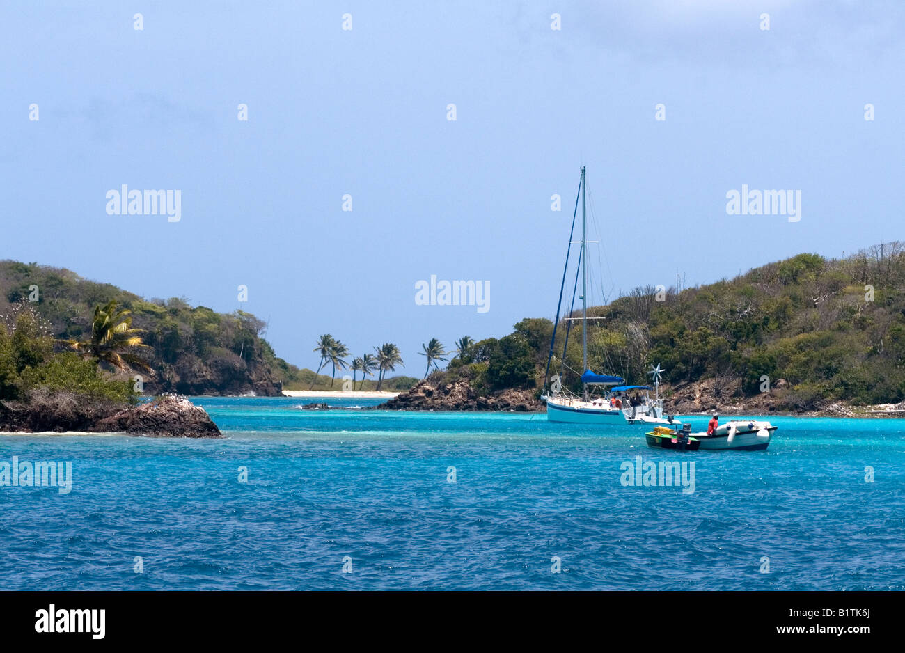 Water taxi and yacht between two islands - Petit Rameau and Petit Bateau - in the Tobago Cays, Eastern Caribbean Stock Photo