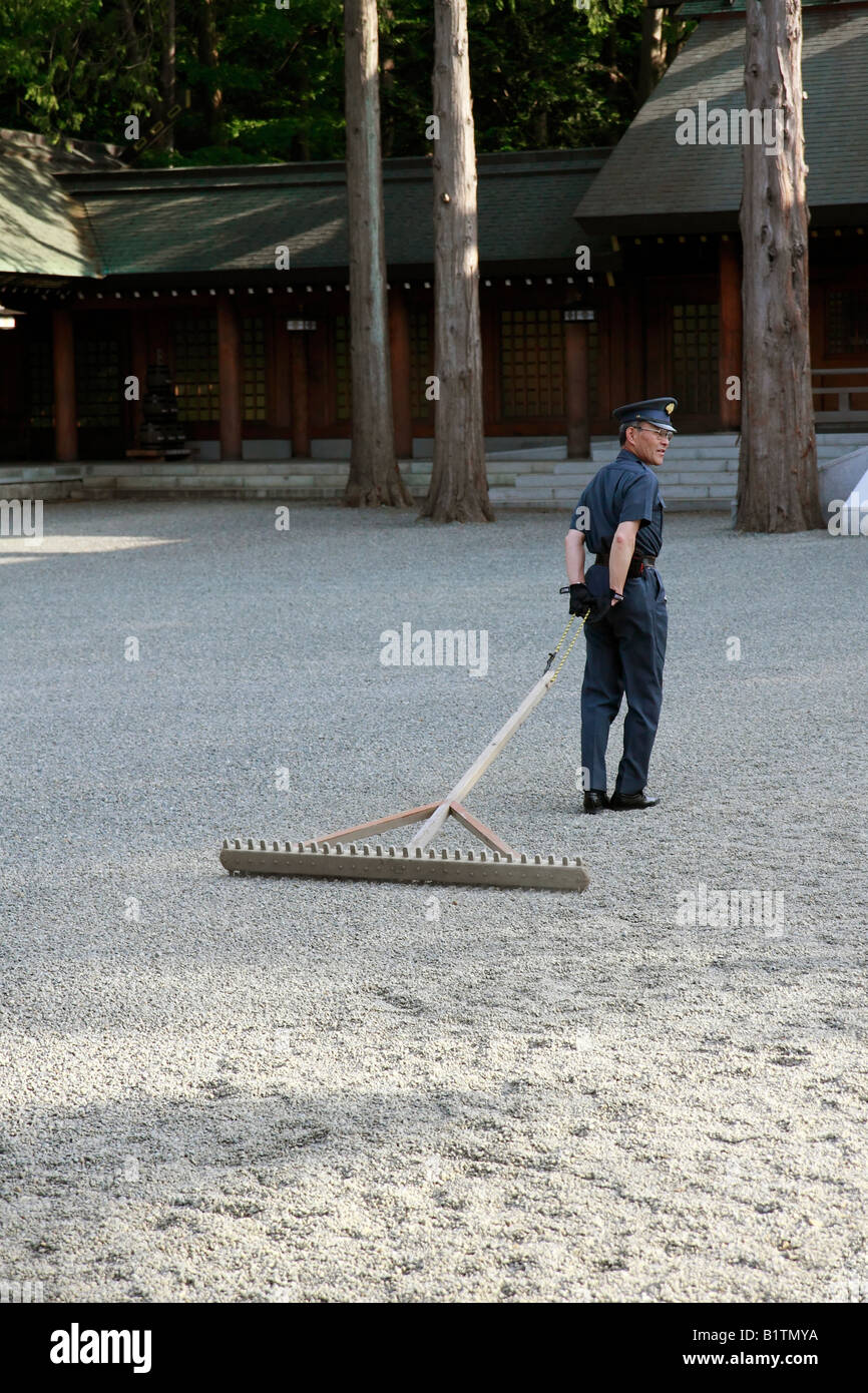 Security Guard Raking Gravel At A Shinto Shrine In Sapporo Japan Stock Photo Alamy
