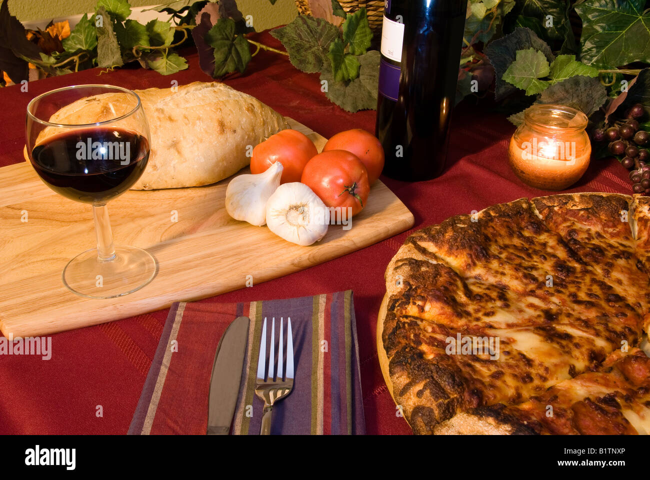 Classic Italian food setting with wine pizza bread and trimmings Stock Photo