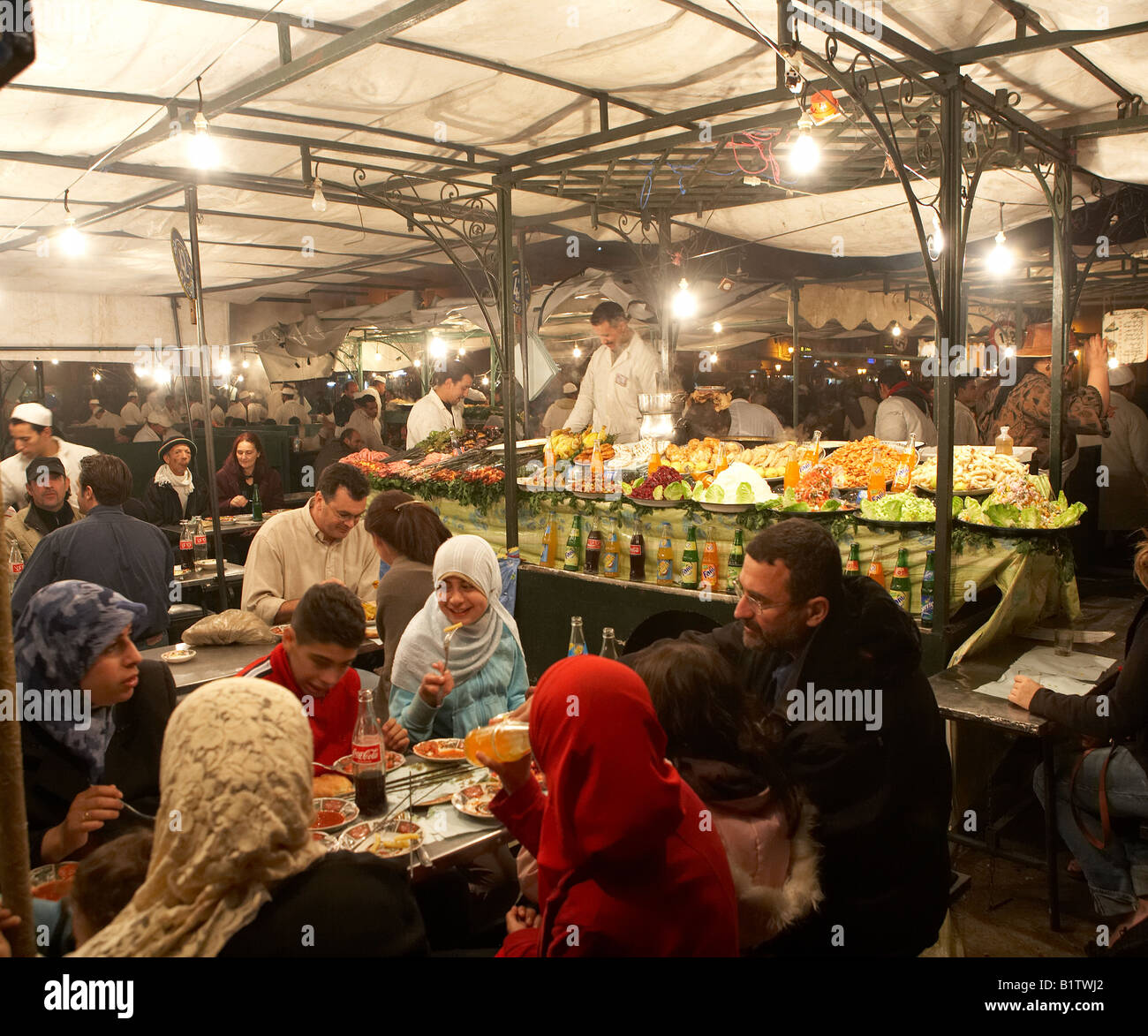 Family having dinner at market, Jemaa el Fna Marrakesh, Morocco Stock Photo