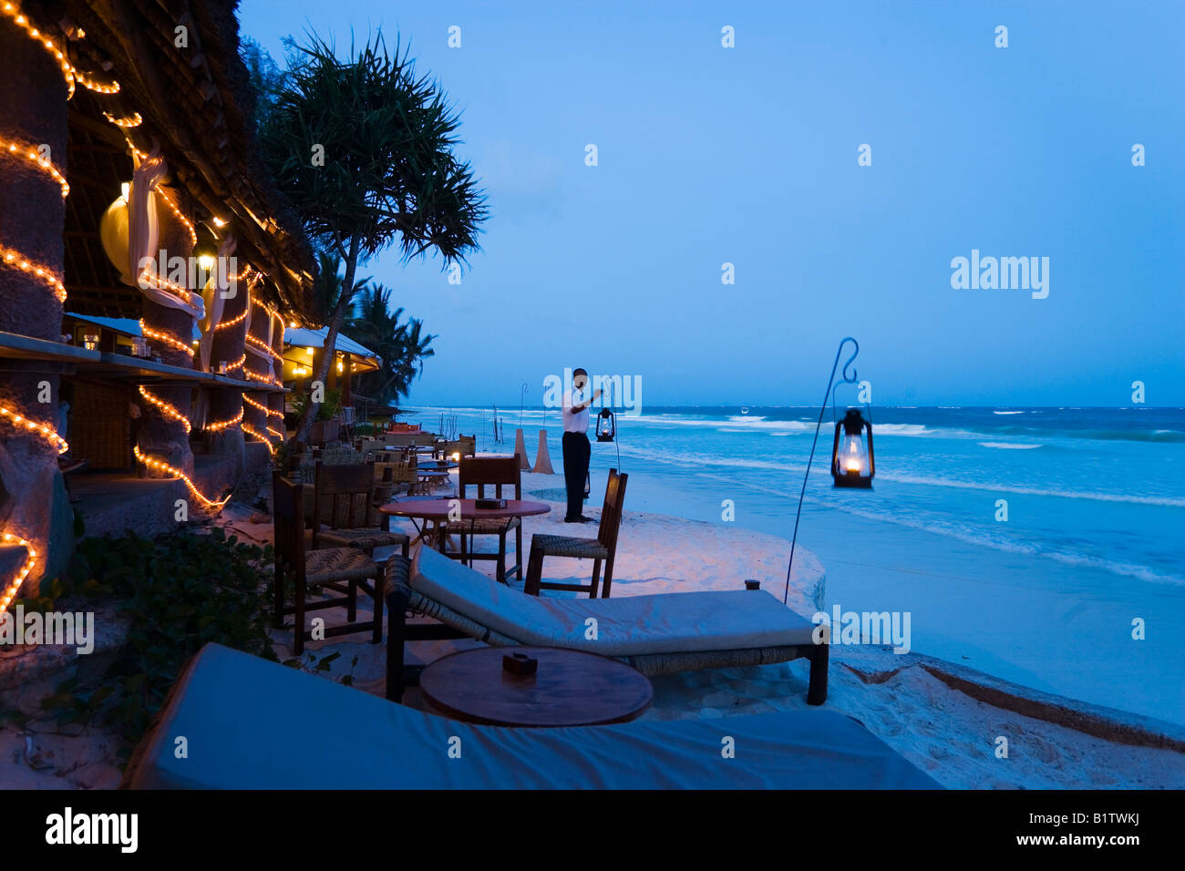 Waiter arranging lanterns The Sands at Nomad Diani Beach Kenya Stock Photo