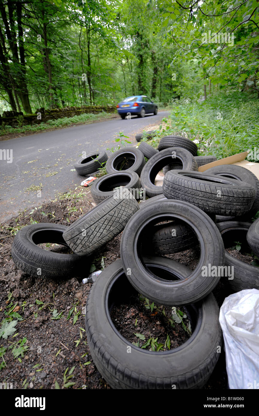 Illegally dumped tyres left by fly-tippers at the side of a country lane in the Cotswolds. Picture by Jim Holden. Stock Photo