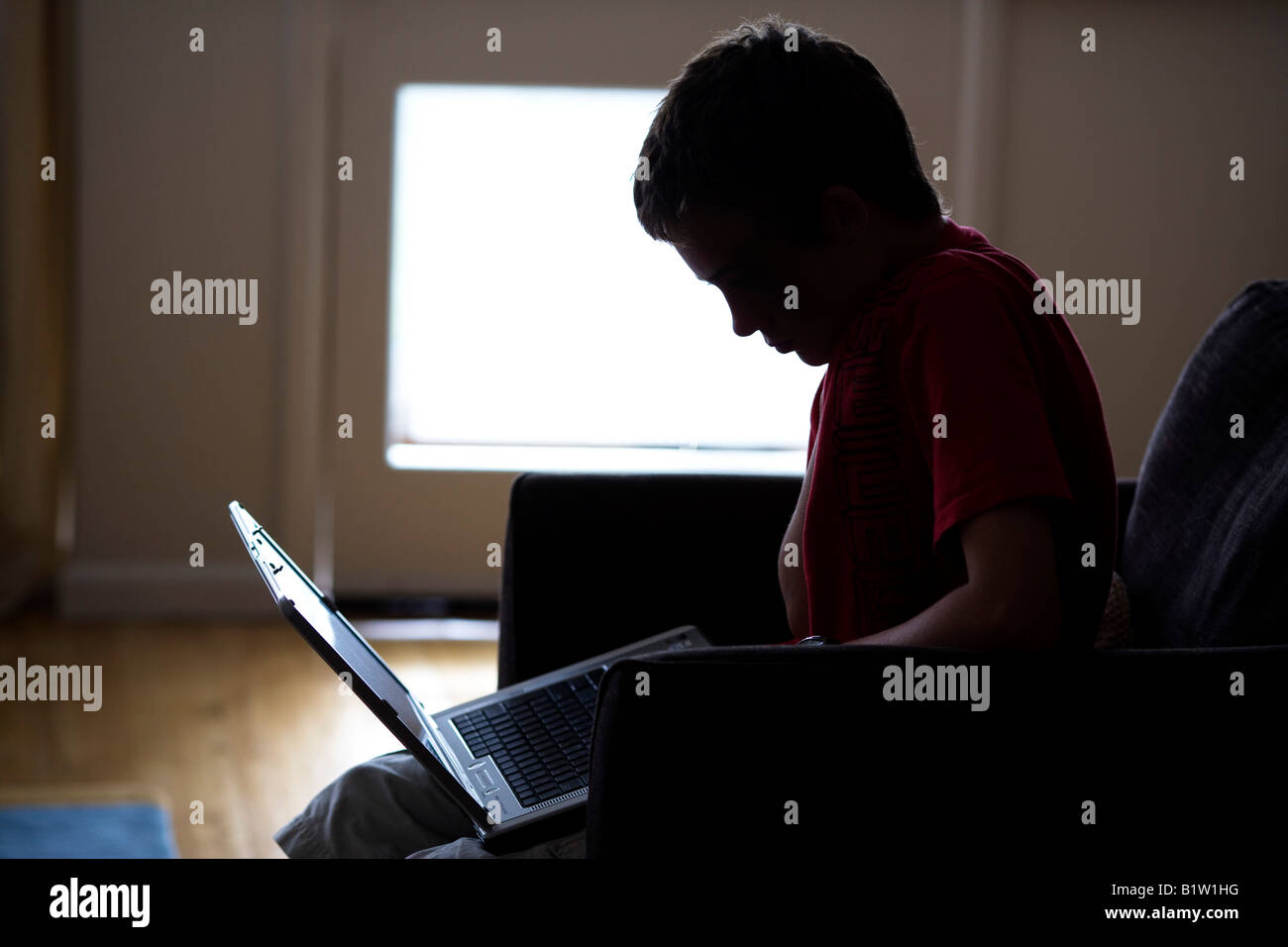 teenage boy working on laptop computer Stock Photo
