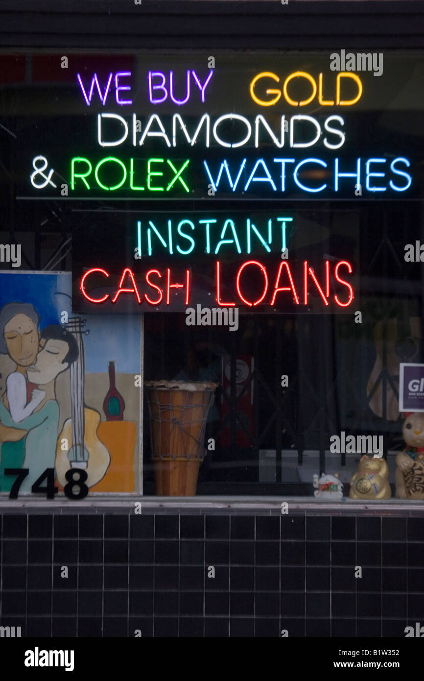 Colorful neon signs light up an urban pawn shop window. Stock Photo
