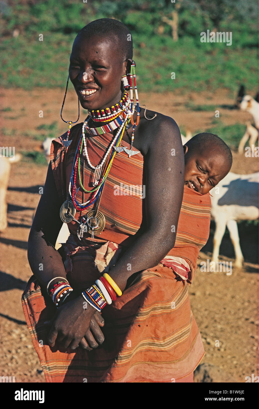 Maasai woman in traditional dress with baby on her back Southern Kenya